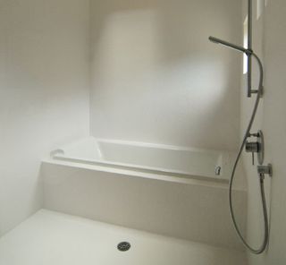 Bathroom with bathtub and white walls