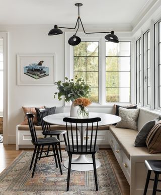 Dining nook with build in bench, circular table and black dining chairs