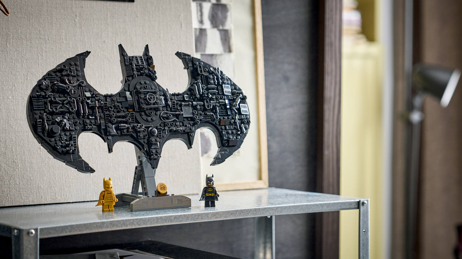 Lego Batman logo and minifigures on a shelf unit