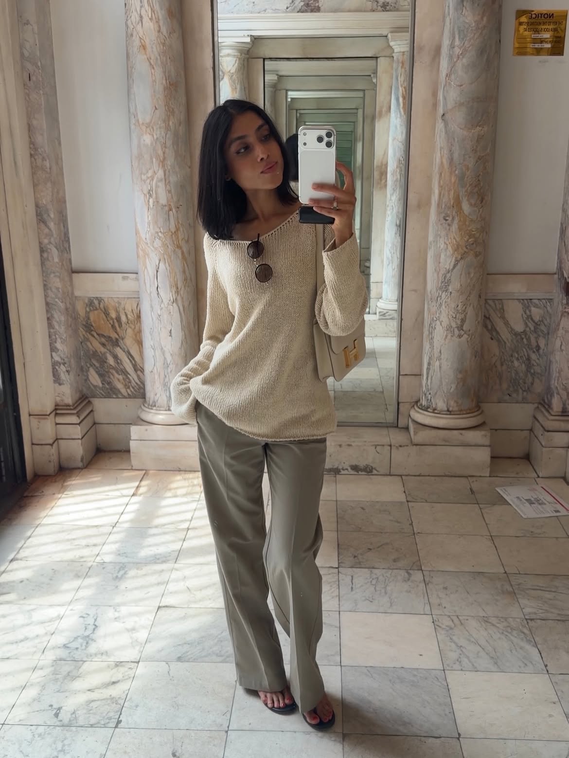 Shay June wearing an open-knit Khaite sweater with tailored trousers