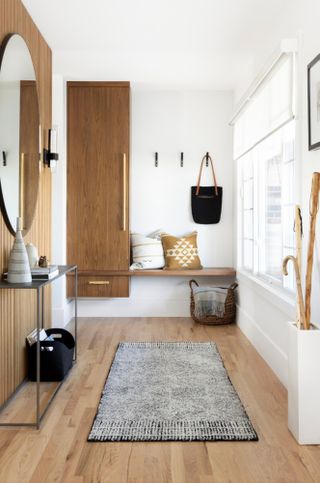 Hallway with ceiling-to-floor wooden cupboard, coat hooks and bench