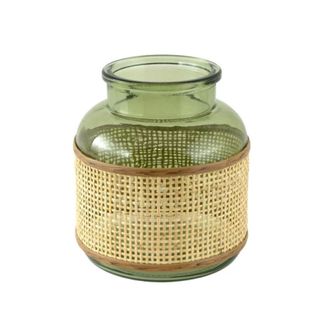 A curved green glass vase with a light rattan wrap around it