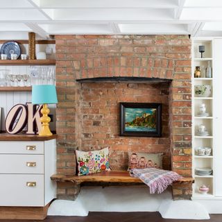 wooden bench built into old facebrick fireplace converted into seating area