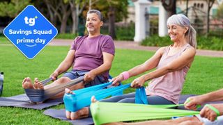 Older male and female sitting on grass stretching using resistance bands, TG savings badge top left