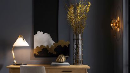 A pendant lighting hanging over a vase of flowers and a chair