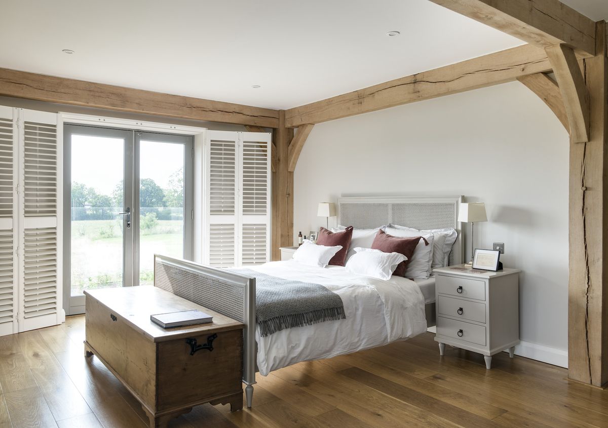 white bedroom with oak frame and balcony