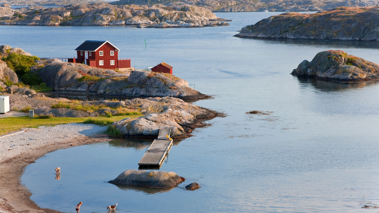 View of bathers taking a swim in the sea on the coastline of Tjörn