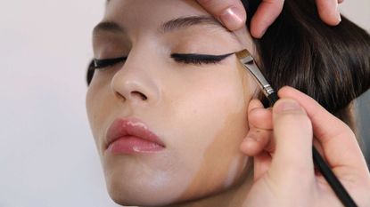 To illustrate eyeliner hacks, a model gets makeup applied backstage at the Cushnie Et Ochs fashion show during MADE Fashion Week Fall 2014 at Milk Studios 