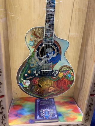 An Alice in Wonderland-themed 12-string acoustic guitar, displayed at the 2023 NAMM show