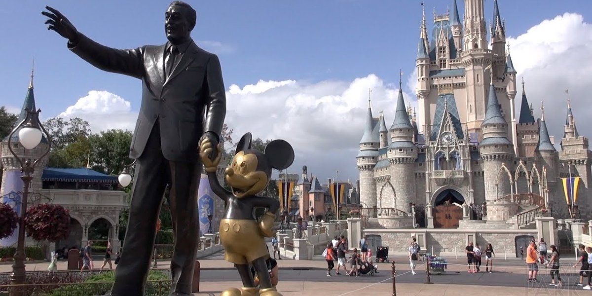 Walt Disney World the Walt and Mickey statue with Cinderella&#039;s castle in the distance