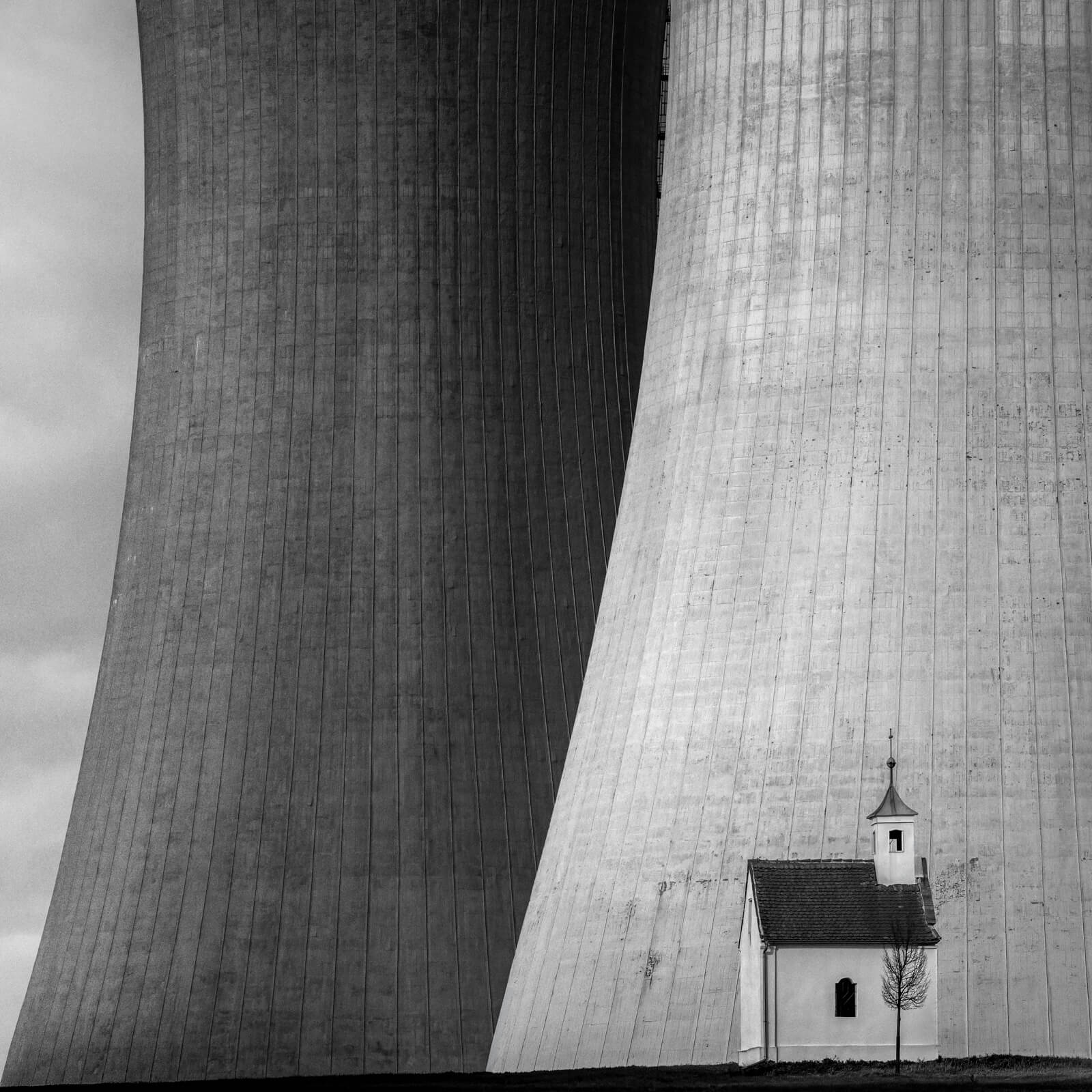 Chapel in front of nuclear power plant cooling tower.