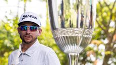 John Catlin looks on with the Macao Open trophy out of focus in the foreground