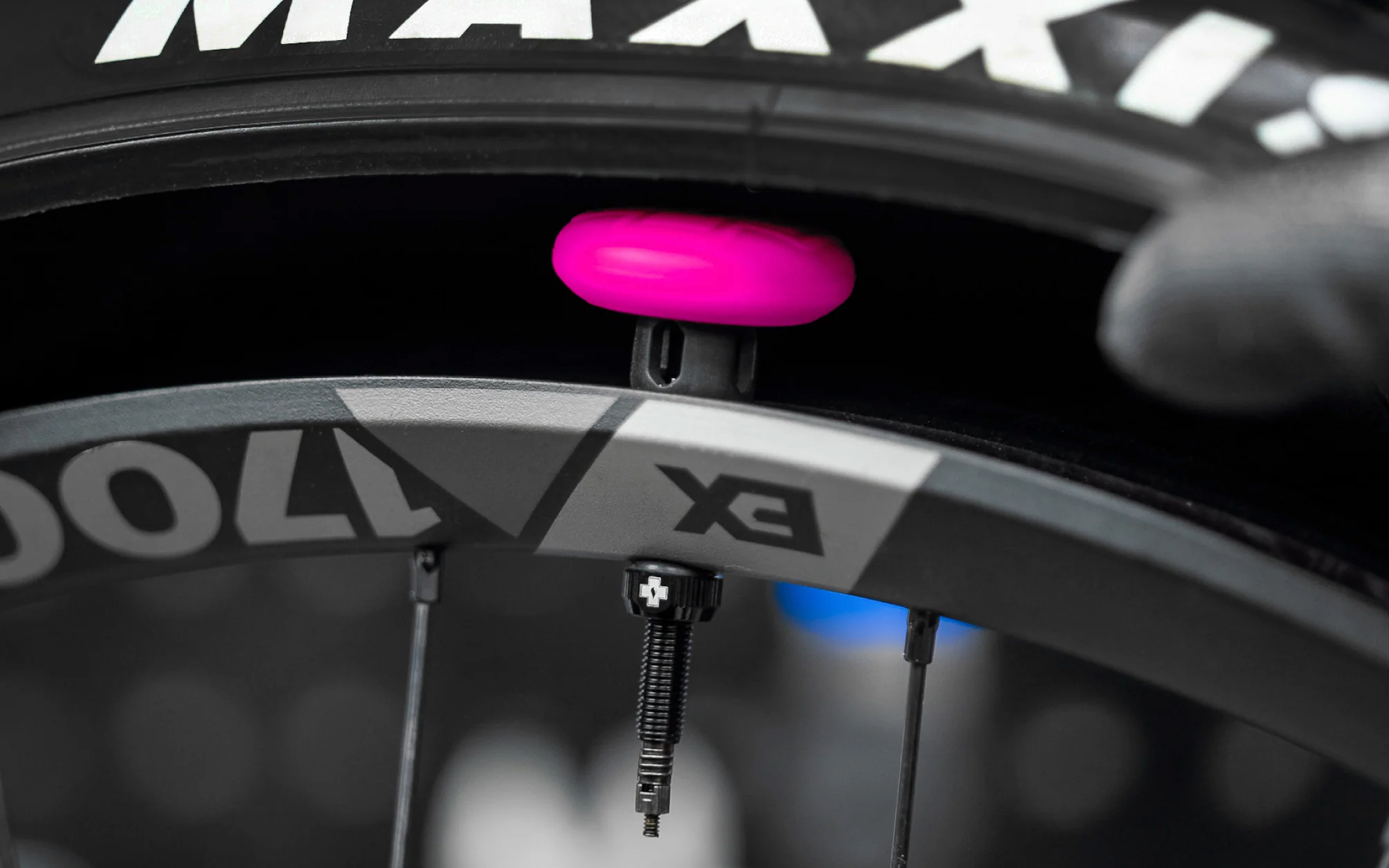 The Muc-Off Stealth AirTag holder installed on bike wheel, showing how the product works