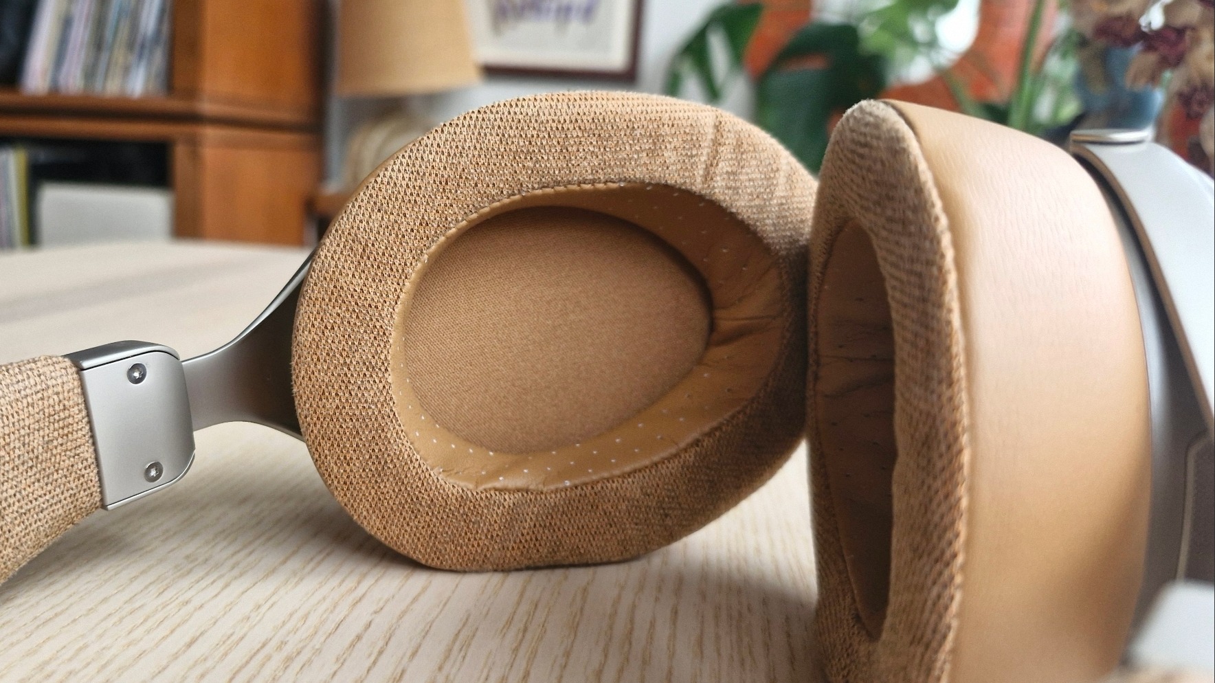 Closup of the pleather interior of the earcups of the Sivga Robin SV021 Pro over-ear headphones, on a wooden surface.