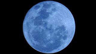 Image of a blue moon - a full moon colored slightly blue. But a blue moon is not really colored blue. 