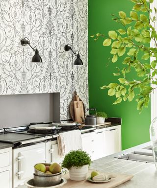 Kitchen wall decor featuring a black and white baroque print wallpaper alongside a bright green wall, with a white Aga and cabinetry.