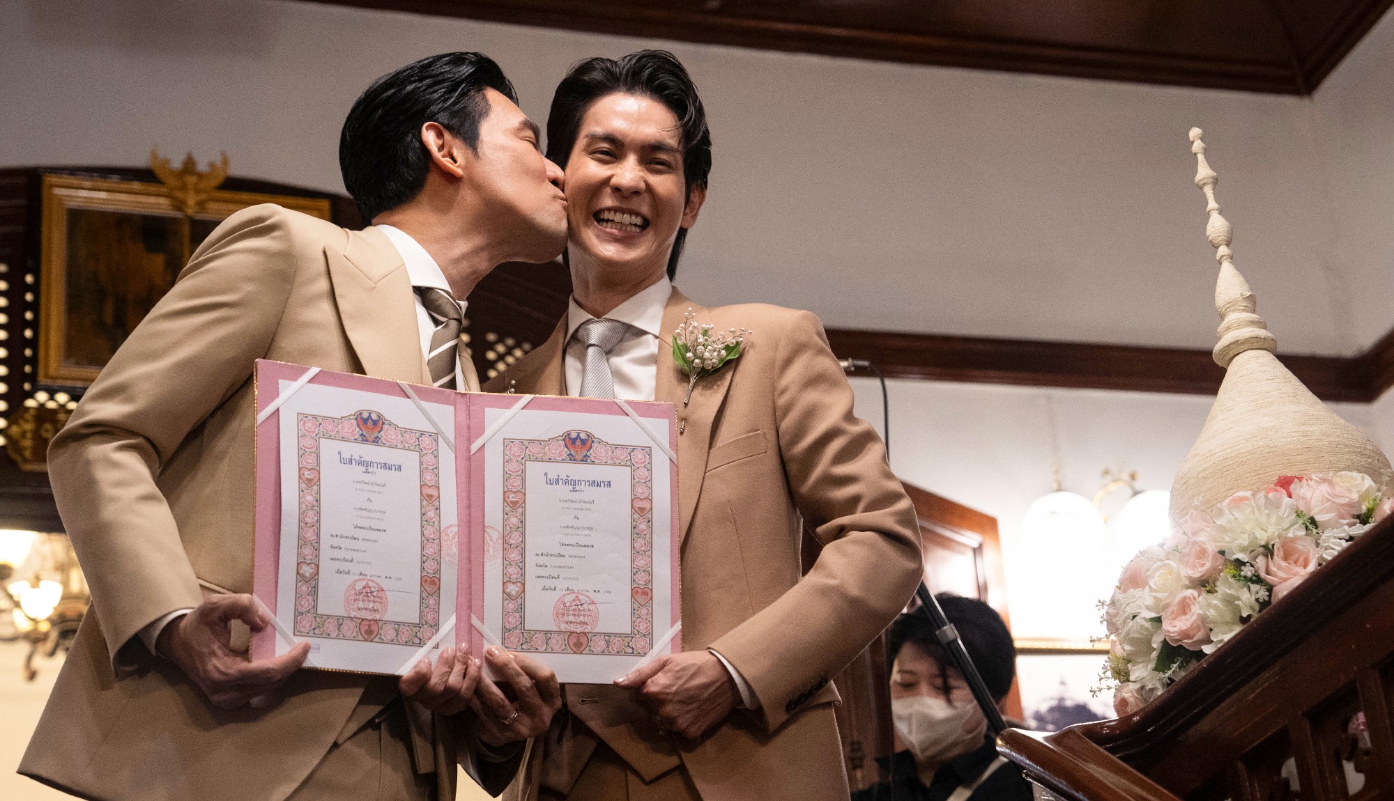 Thai actors Apiwat Apiwatsayree and Sappanyoo Panatkool pose for pictures following their marriage ceremony at Bangkok's Phra Nakhon registry office