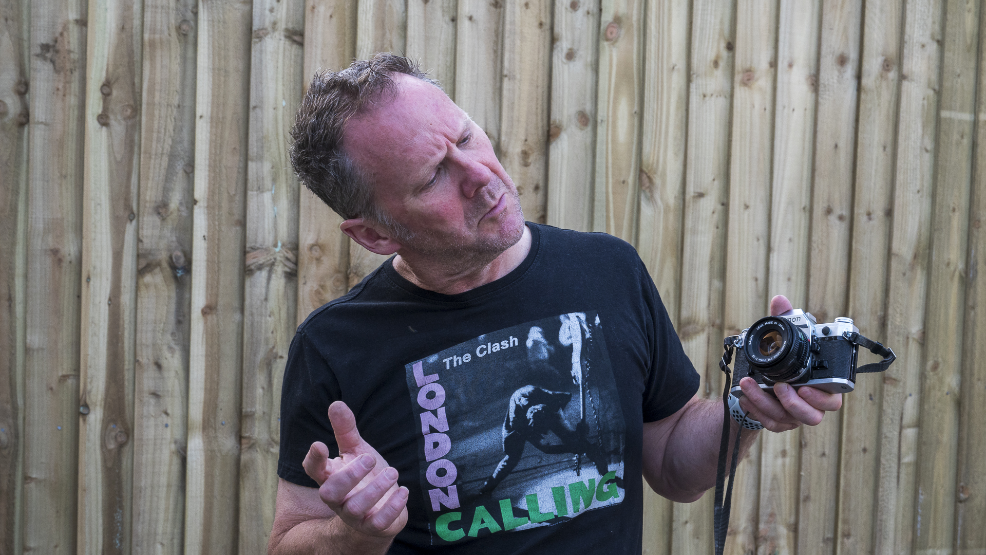 Man holding a Canon AE-1 film SLR and looking a bit confused (at least that was the idea)