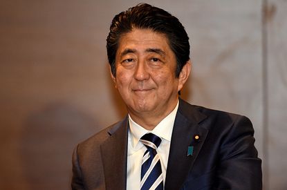 Japan's Prime Minister Shinzo Abe smiles for the camera during a visit to Australia. 