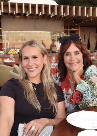 Two women wearing gold jewelry.