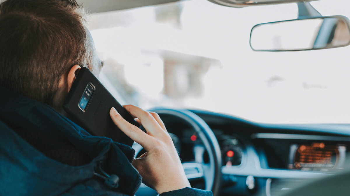 Man driving while using his phone