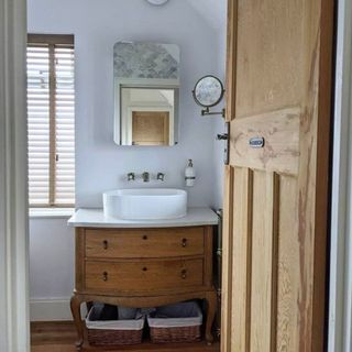 Brown wooden sink unit in blue bathroom
