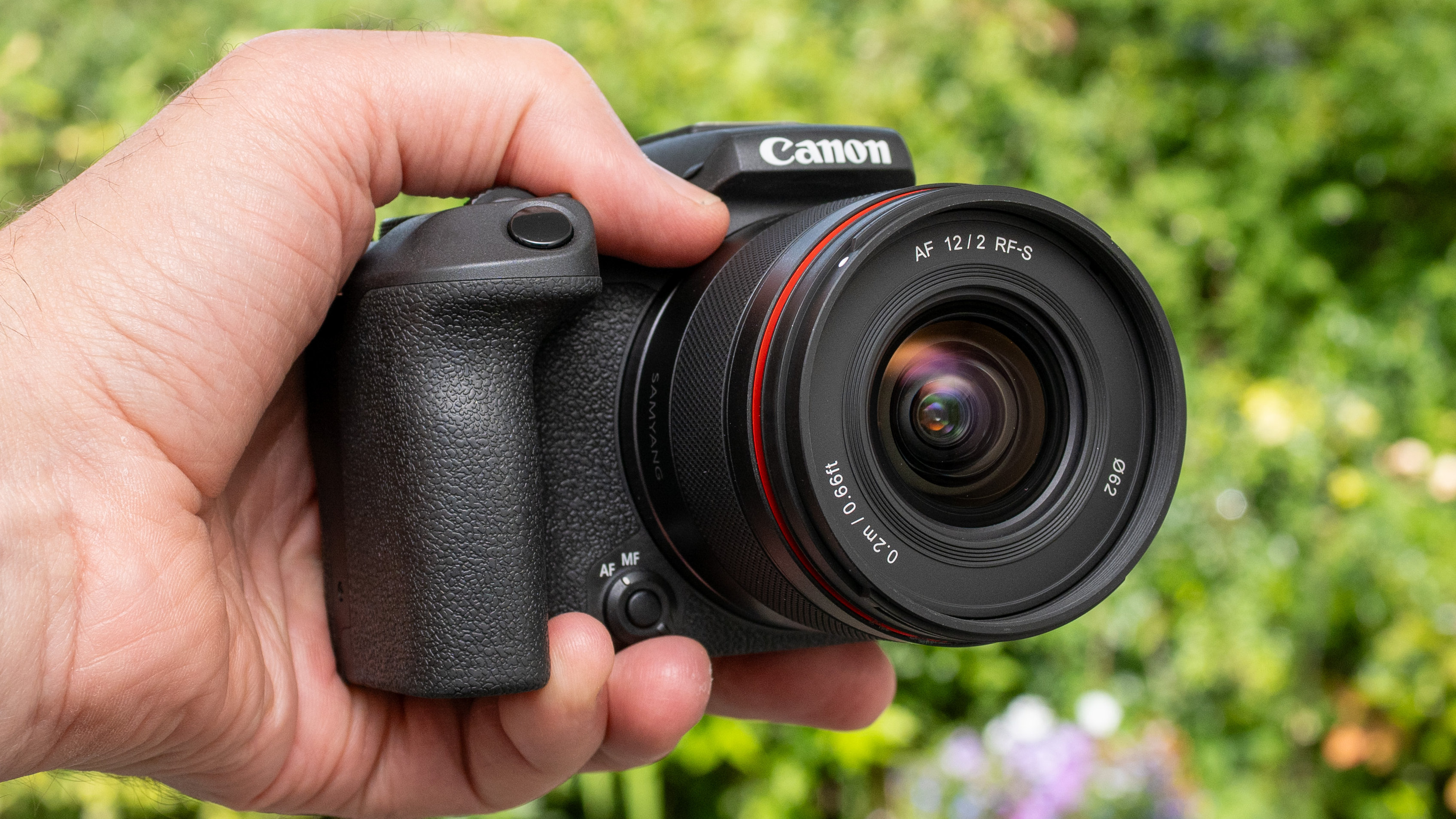 LK Samyang AF 12mm f/2 RF-S product shot lens held in hand