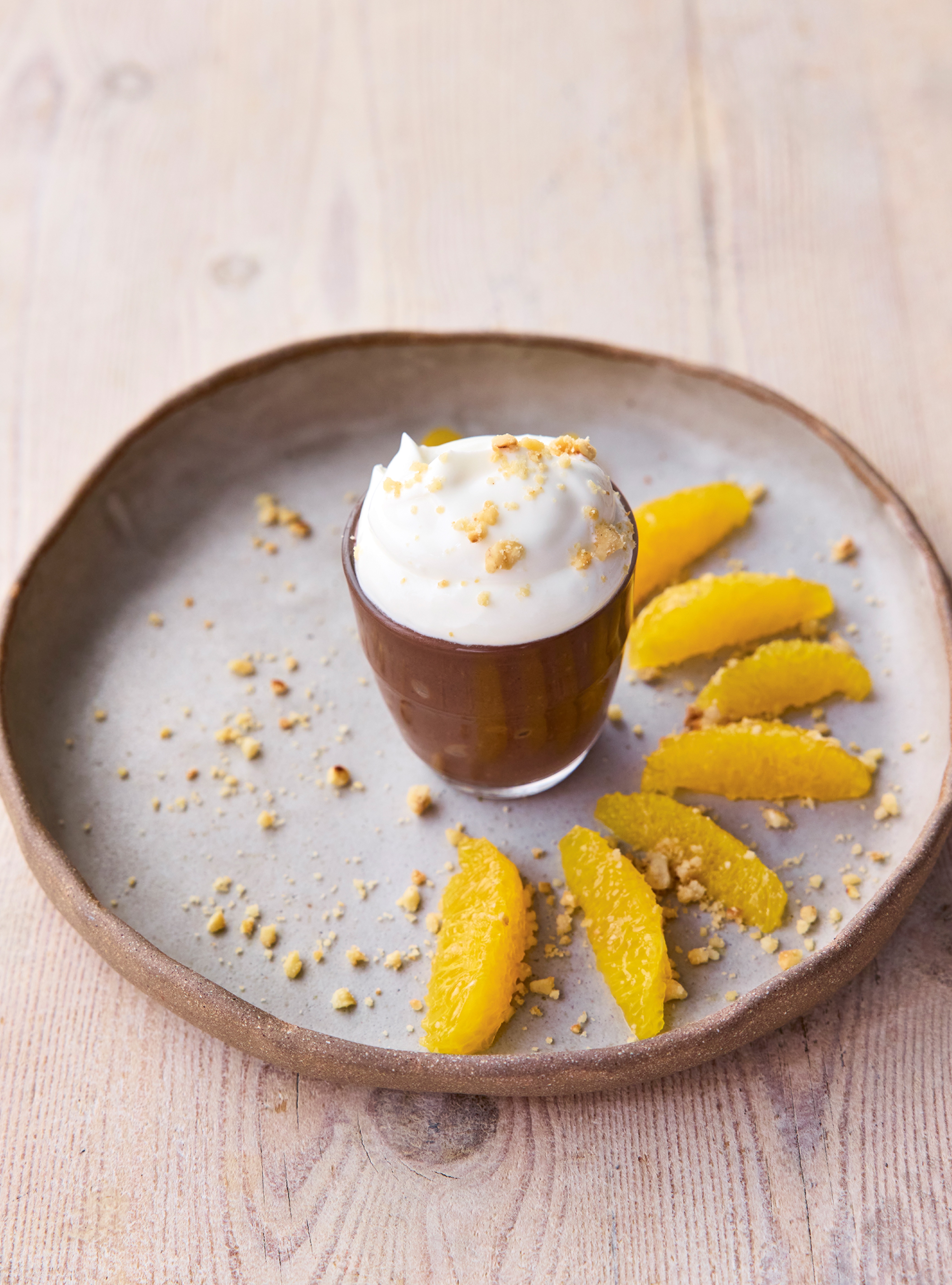 A pot of chocolate mousse surrounded by orange slices