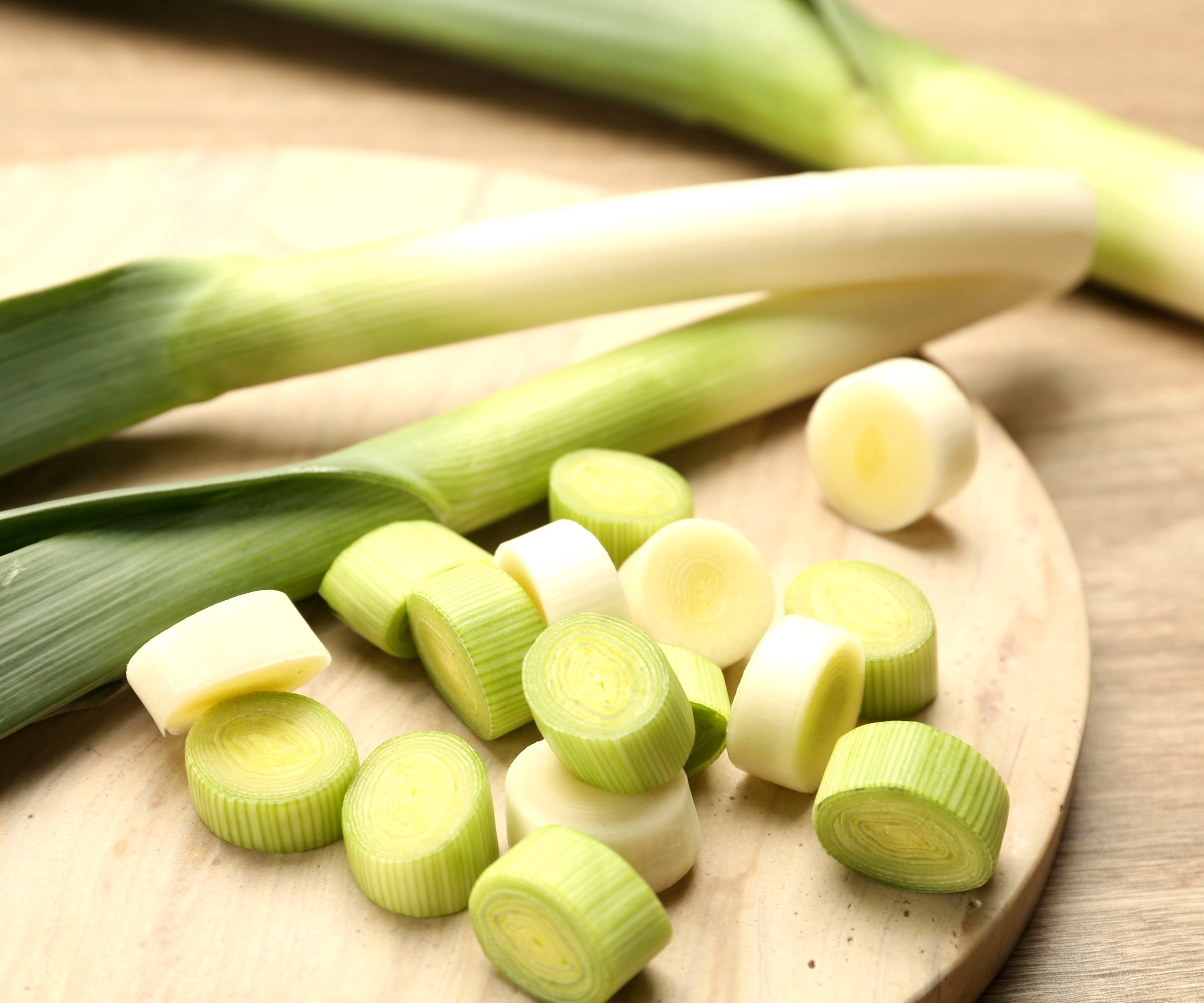 leeks with chopped leek on wooden board