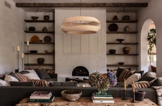 Black U-shaped sofa, exposed wooden beams and shelves