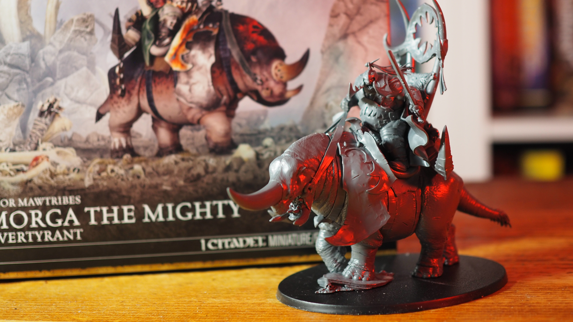 A Tyrant on Glutthorn model beside the Morga the Mighty box, on a wooden surface