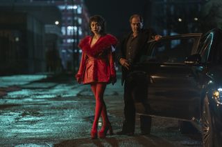 A photo of Sofia Falcone from The Penguin in a furry red coat dress accessorized with matching red tights and Mary Janes.