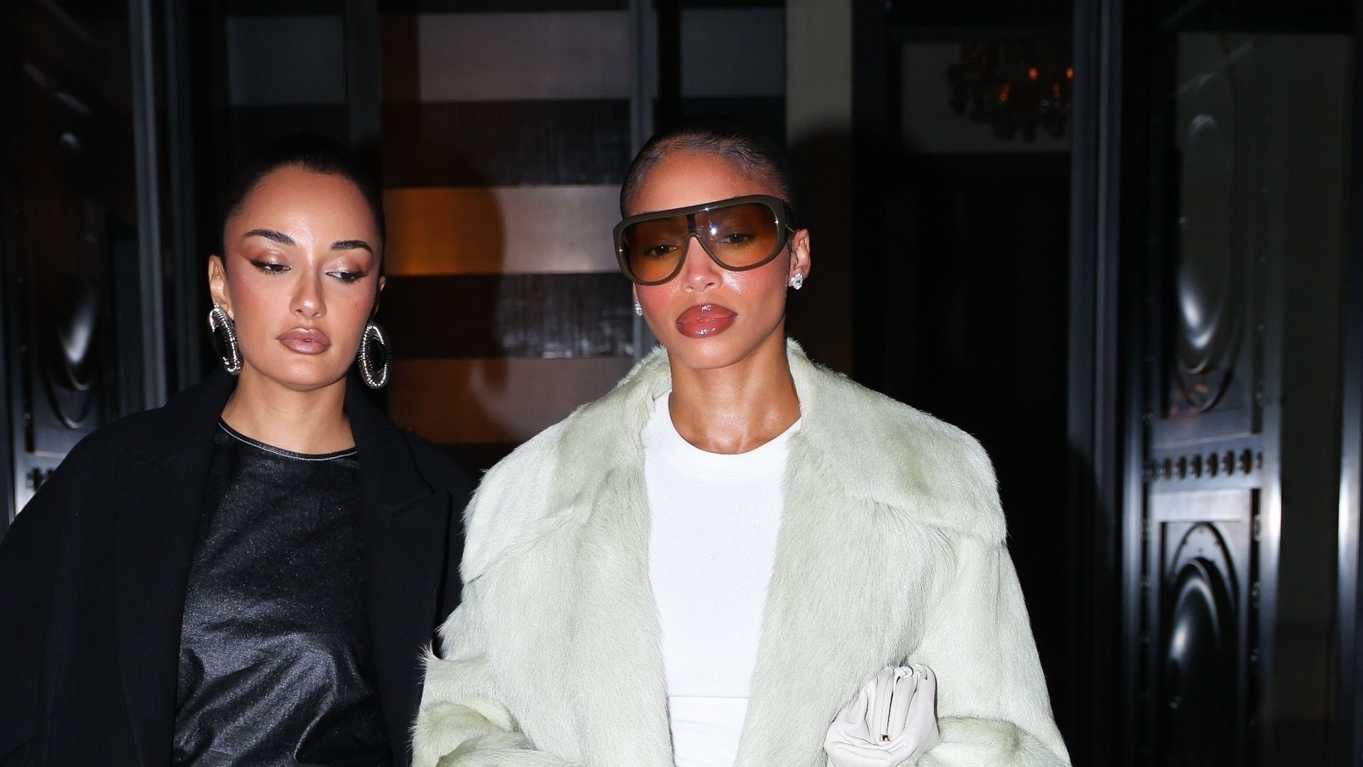 Lori Harvey wearing a coat, white t-shirt, plaid pants, and pointed toe heels