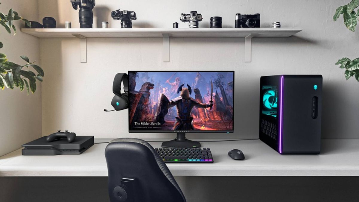 Alienware AW2725QF sitting on desk next to Aurora R16 PC, mouse, keyboard, and generic console on left