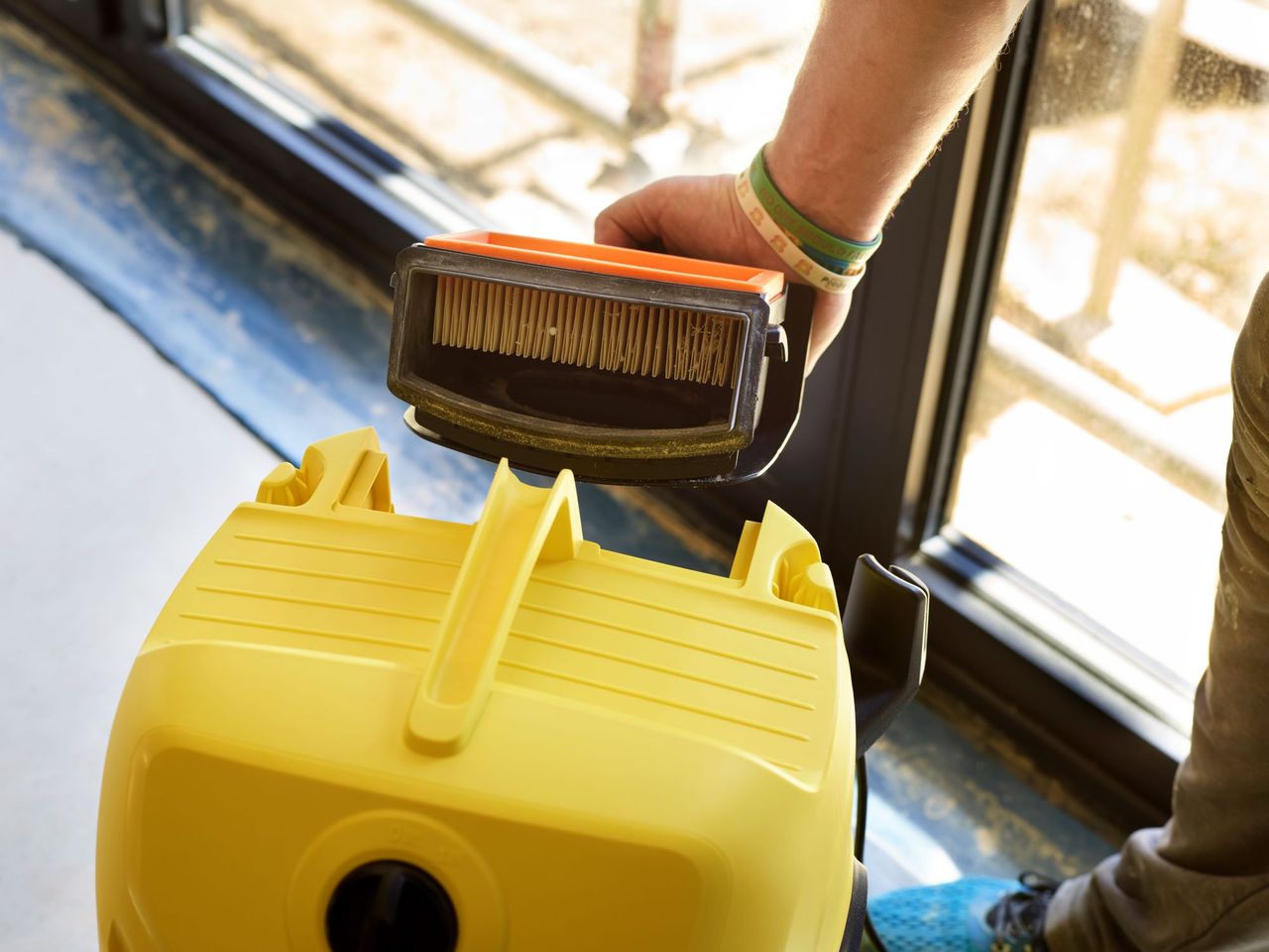 A flat pleat filter is seen popping out of the vacuum in its entirity ready for the dust to be thrown away