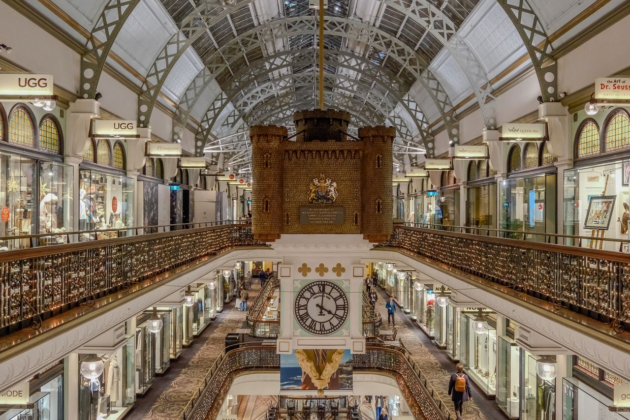 An ornate clock hanging from the roof of a building