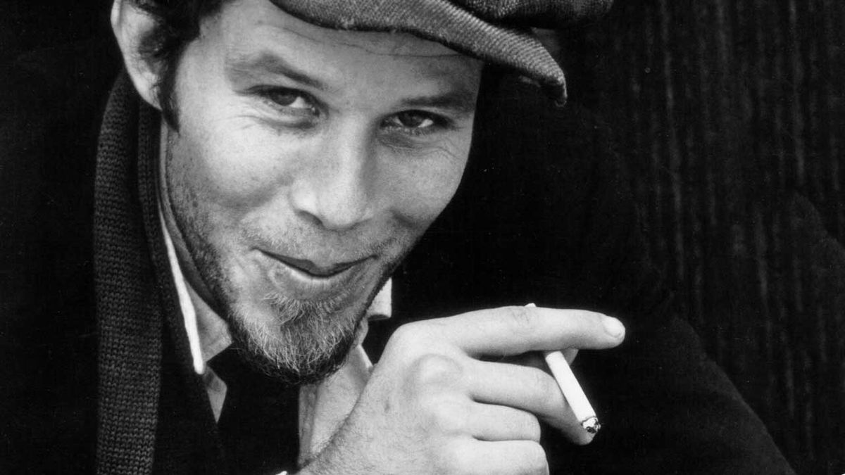 Tom Waits smoking a cigarette and smiling