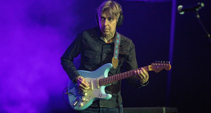 Eric Johnson plays his Daphne Blue Fender Stratocaster onstage during the 2024 G3 Tour, with purple dry ice int he background.