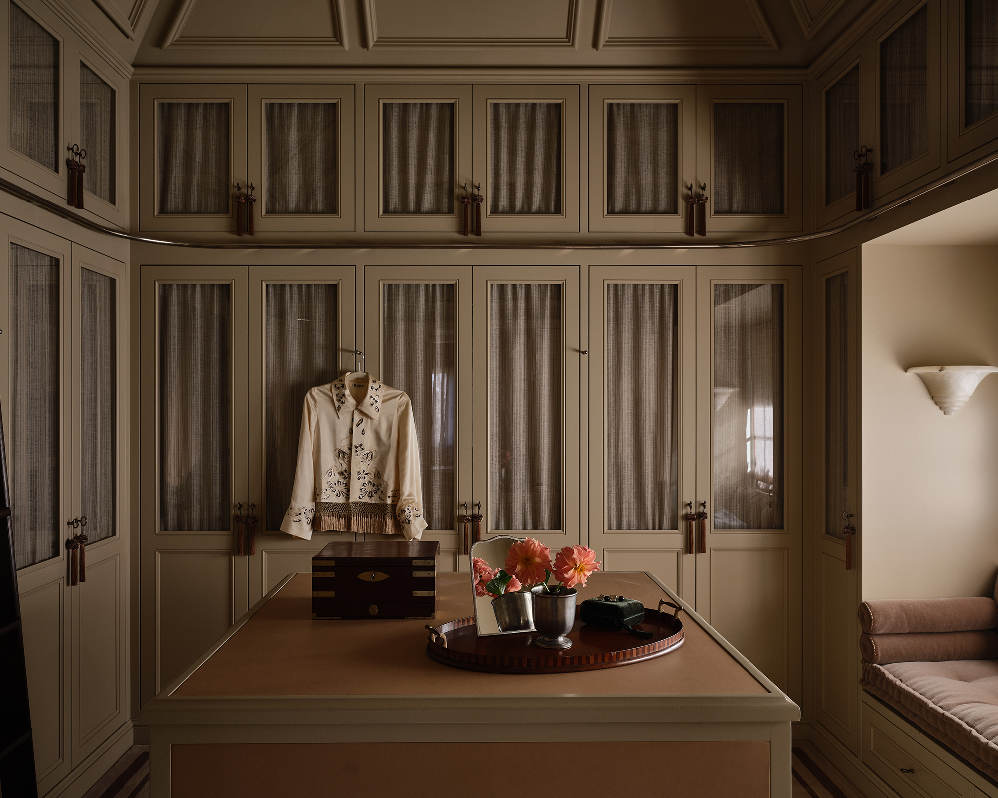 dressing room with floor to ceiling cupboards and a jacket hanging on a door