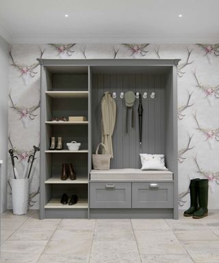 room with grey and pink stag wallpaper, grey freestanding cupboard with seat and boot room style storage