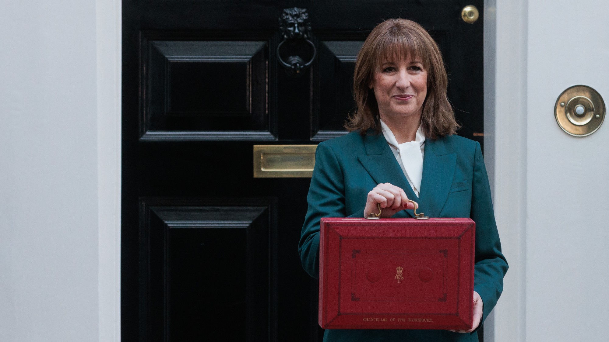 Rachel Reeves standing outside the door of 11 Downing Street with the red Budget box