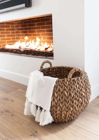 lit fire with basket, throw in blanket, wooden floor