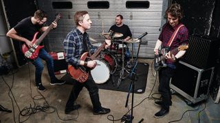 Two guitarists, a bassist and drummer rehearsing