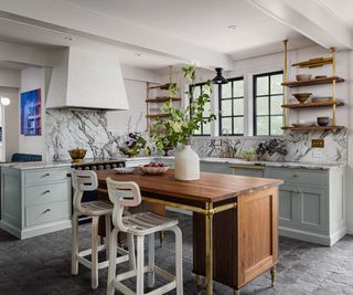 light blue gray kitchen with dark grey kitchen tiled floor and a warm wood small island