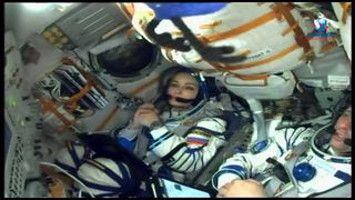 Russian actress Julia Peresild strapped inside a Soyuz capsule ahead of launch to the International Space Station.