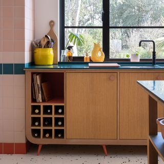 Curved kitchen units on legs with built-in wine storage