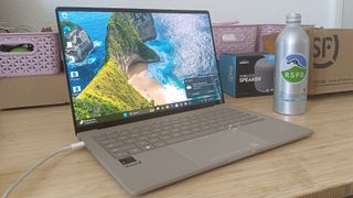 ASUS Zenbook A14 on desk next to a water bottle and some pink stationery baskets