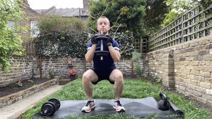 Man performing a dumbbell squat