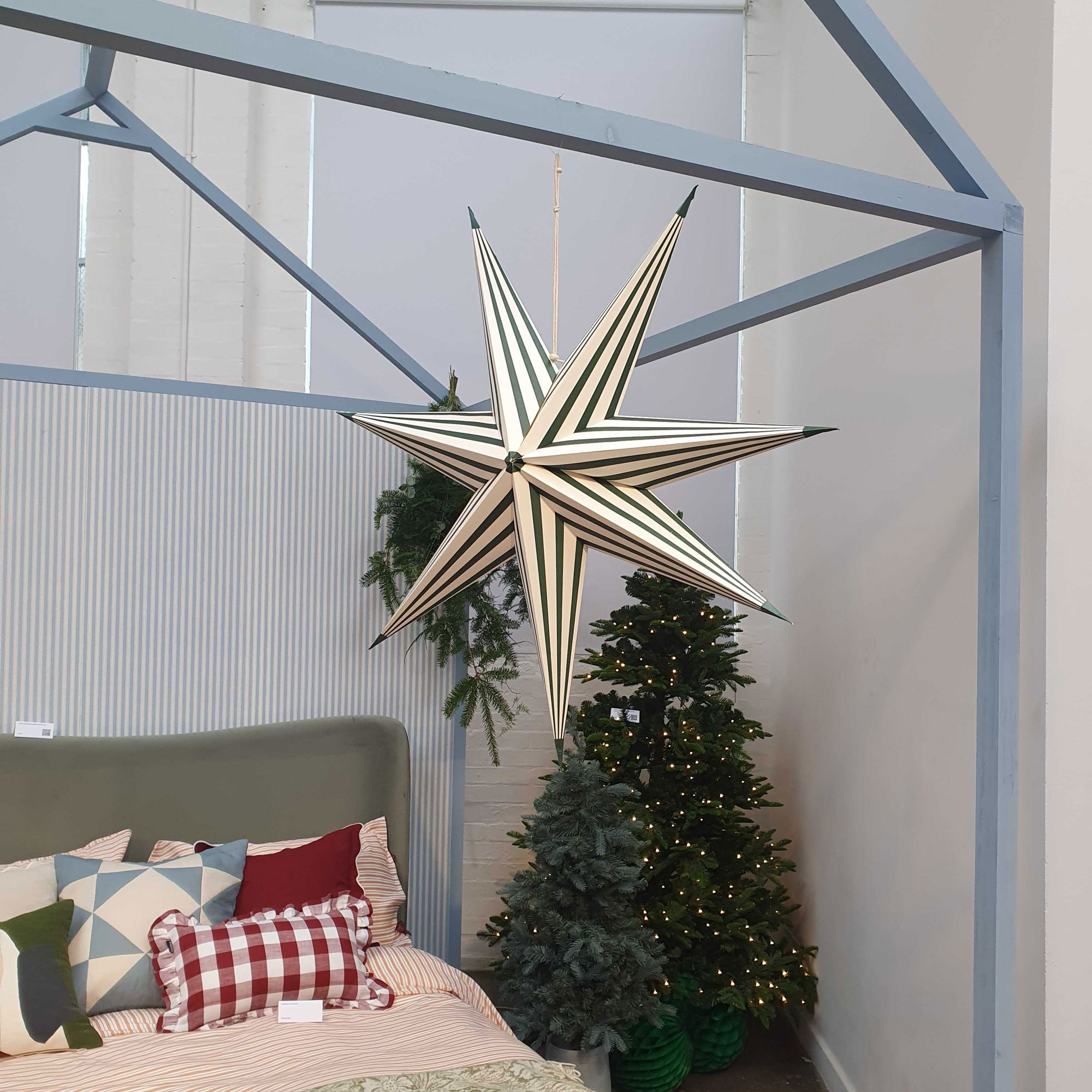 Green stripe star hanging on a beige wall