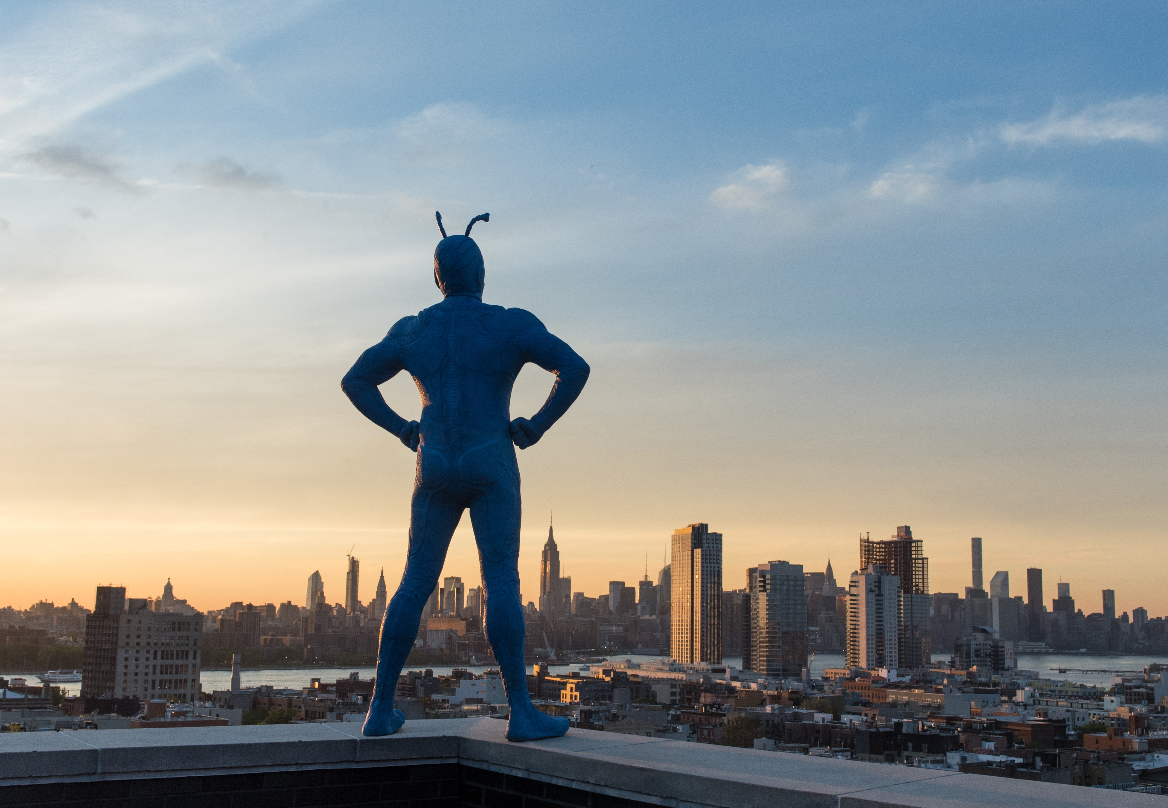 A still taken from the Amazon TV show The Tick or Tick standing on a building